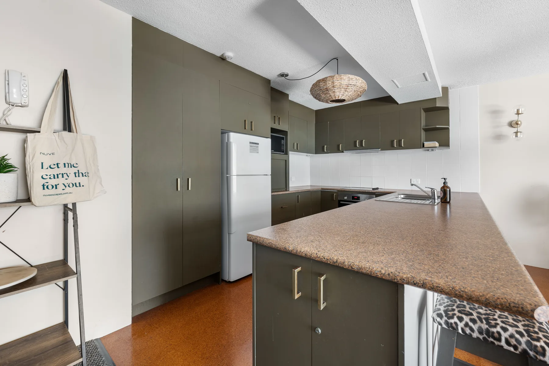 A modern kitchen with dark cabinetry and a large central counter.
