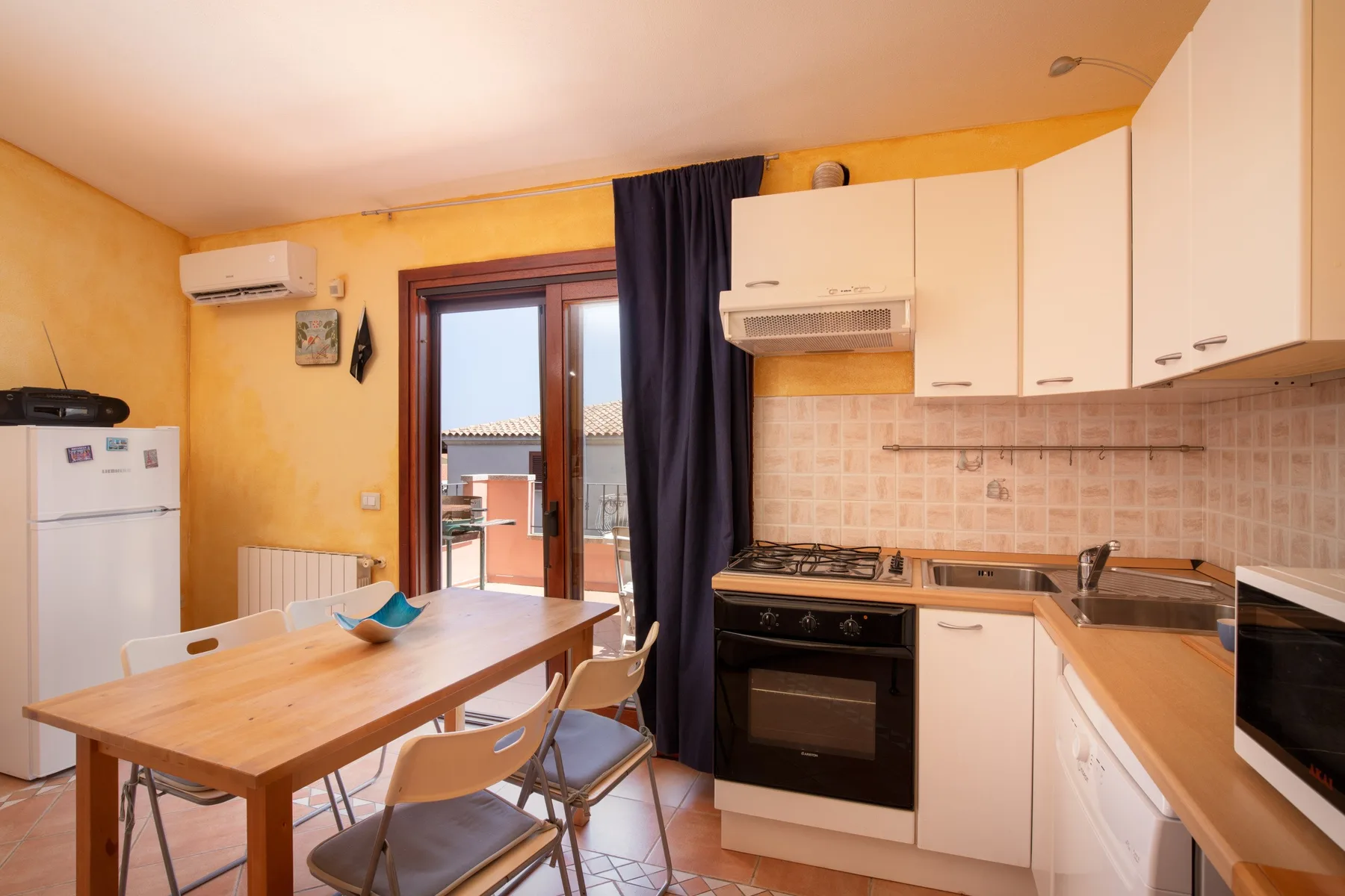 A kitchen with a wooden dining table and built-in cooking appliances.