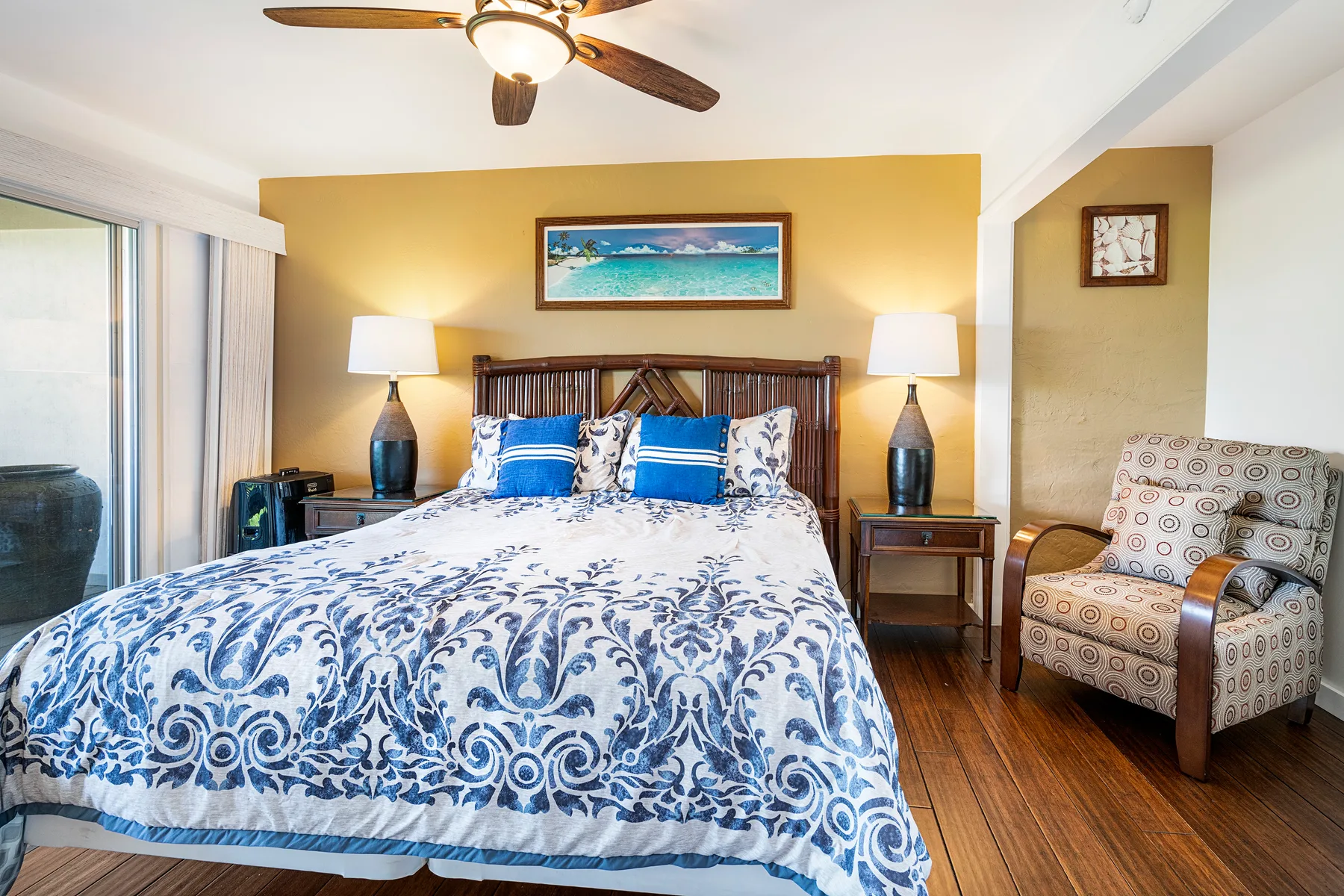 Un dormitorio con una cama vestida con ropa de cama estampada en azul y blanco.