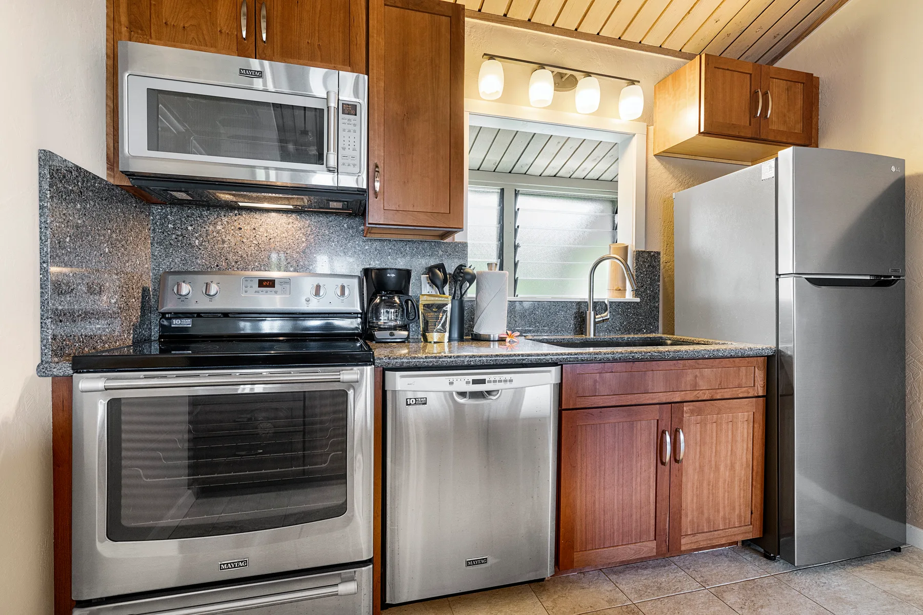 Una cocina con gabinetes de madera, electrodomésticos de acero inoxidable y un fregadero.