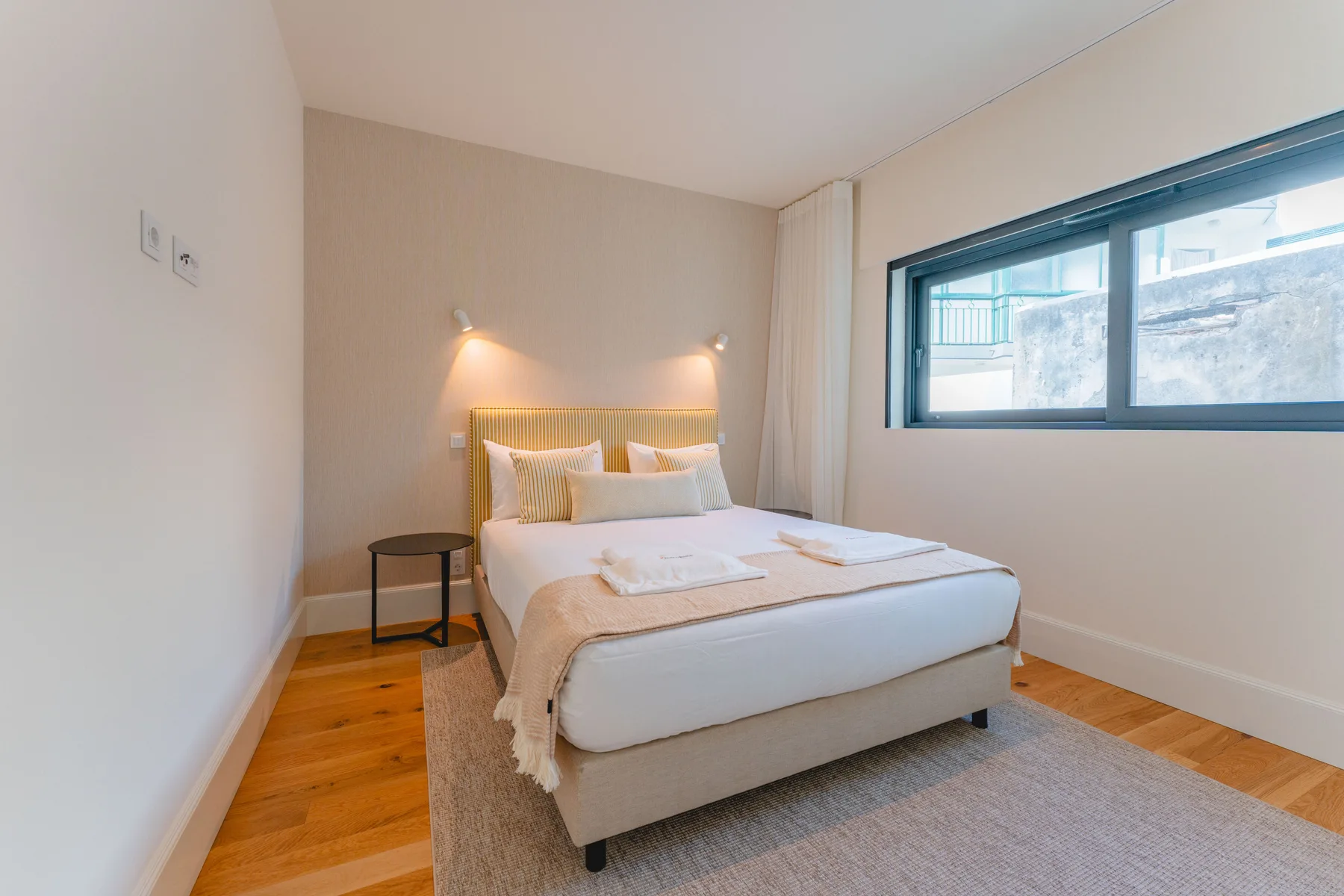 Un dormitorio con una cama doble junto a una ventana grande.
