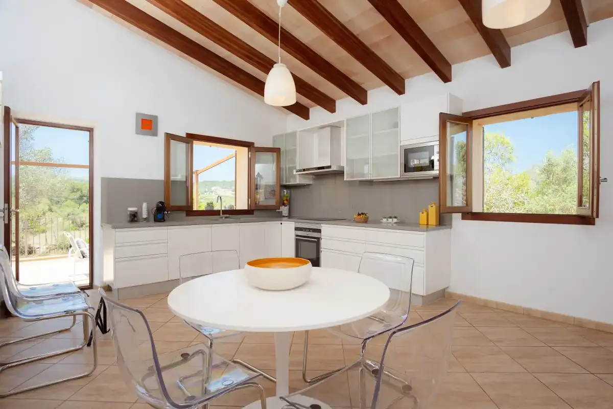 A bright kitchen with white cabinetry and a round dining table.