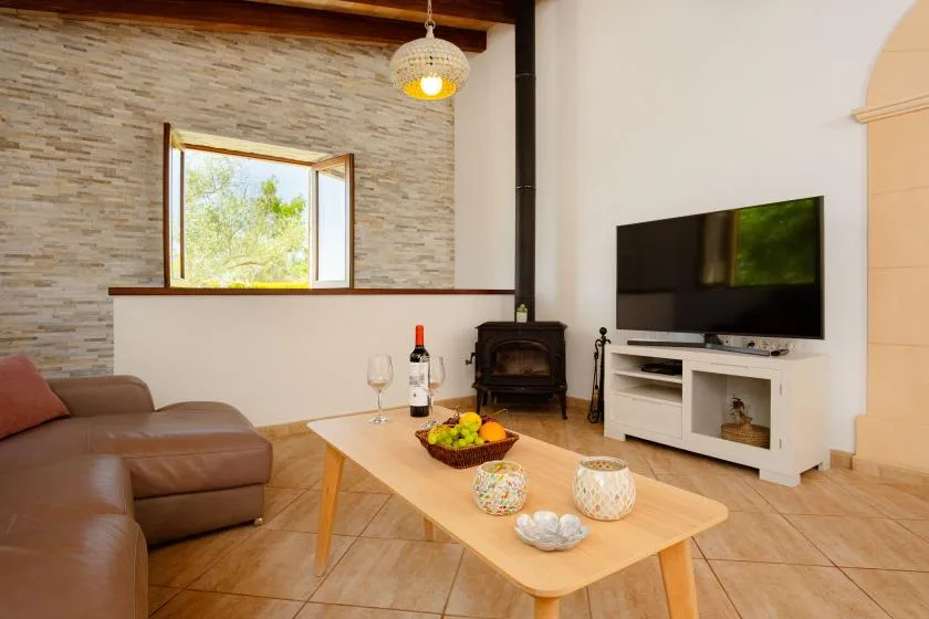 A living room with a television, seating, and a wooden coffee table.