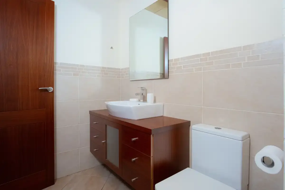 A bathroom with a sink, mirror, and toilet.