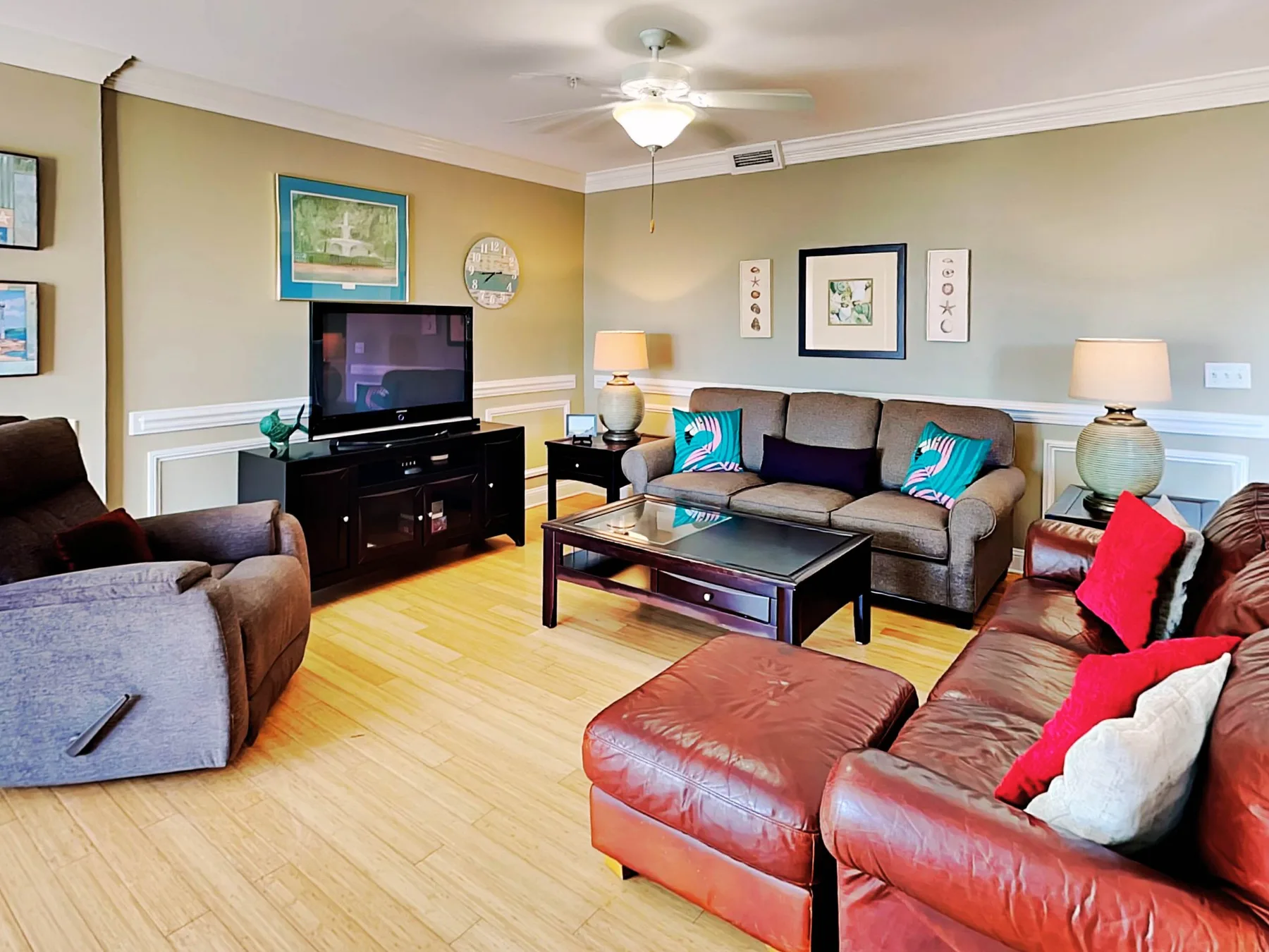 A living room with seating arranged around a coffee table and television.