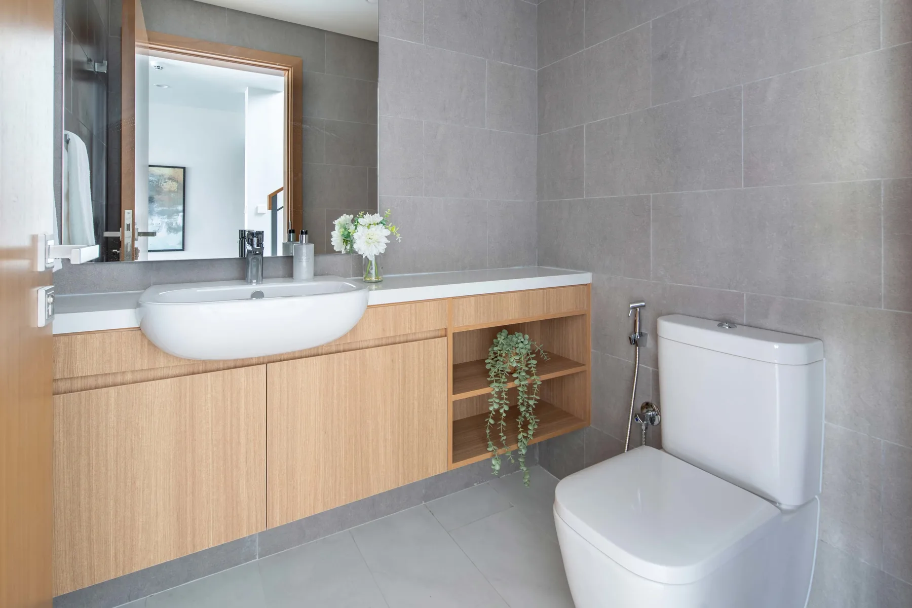 Un baño moderno con un tocador largo, lavabo e inodoro.