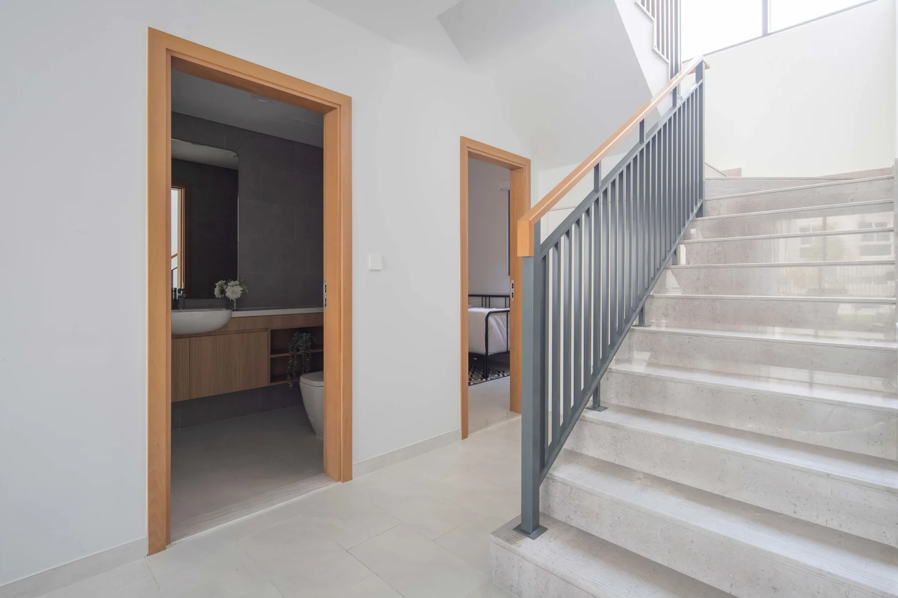 Una escalera interior sube junto a dos puertas abiertas.