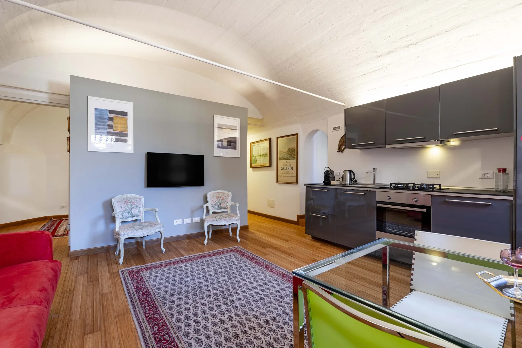 A bright open-plan living area with a compact kitchen and seating.
