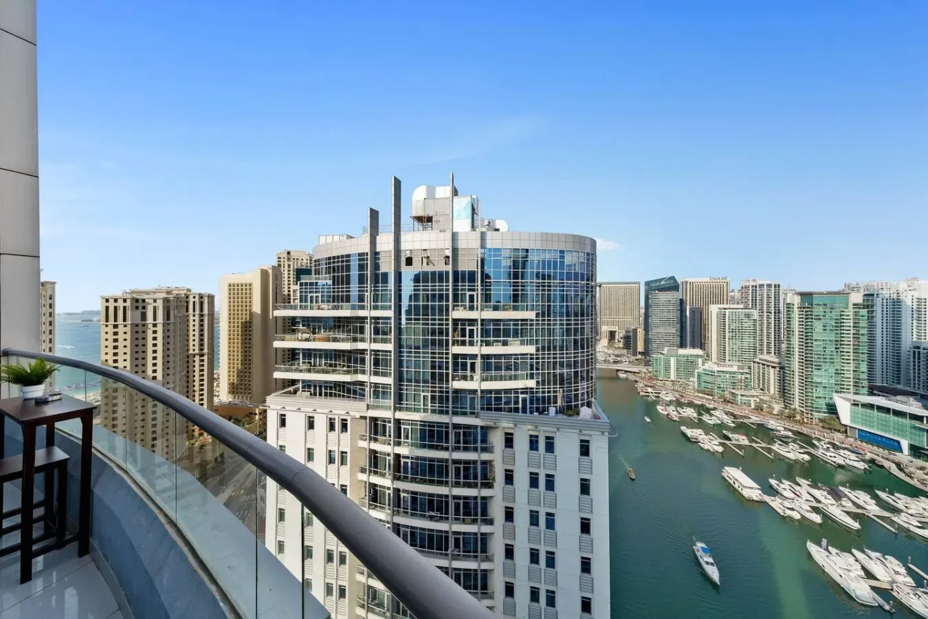 A balcony overlooks modern high-rise buildings and a marina.