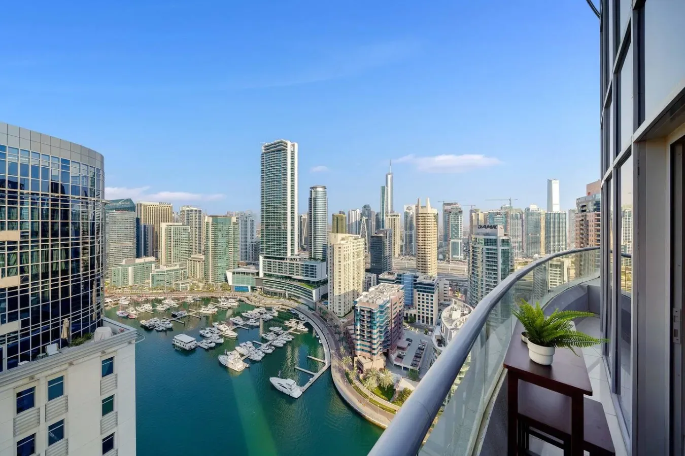 A balcony overlooks a marina and a dense city skyline.