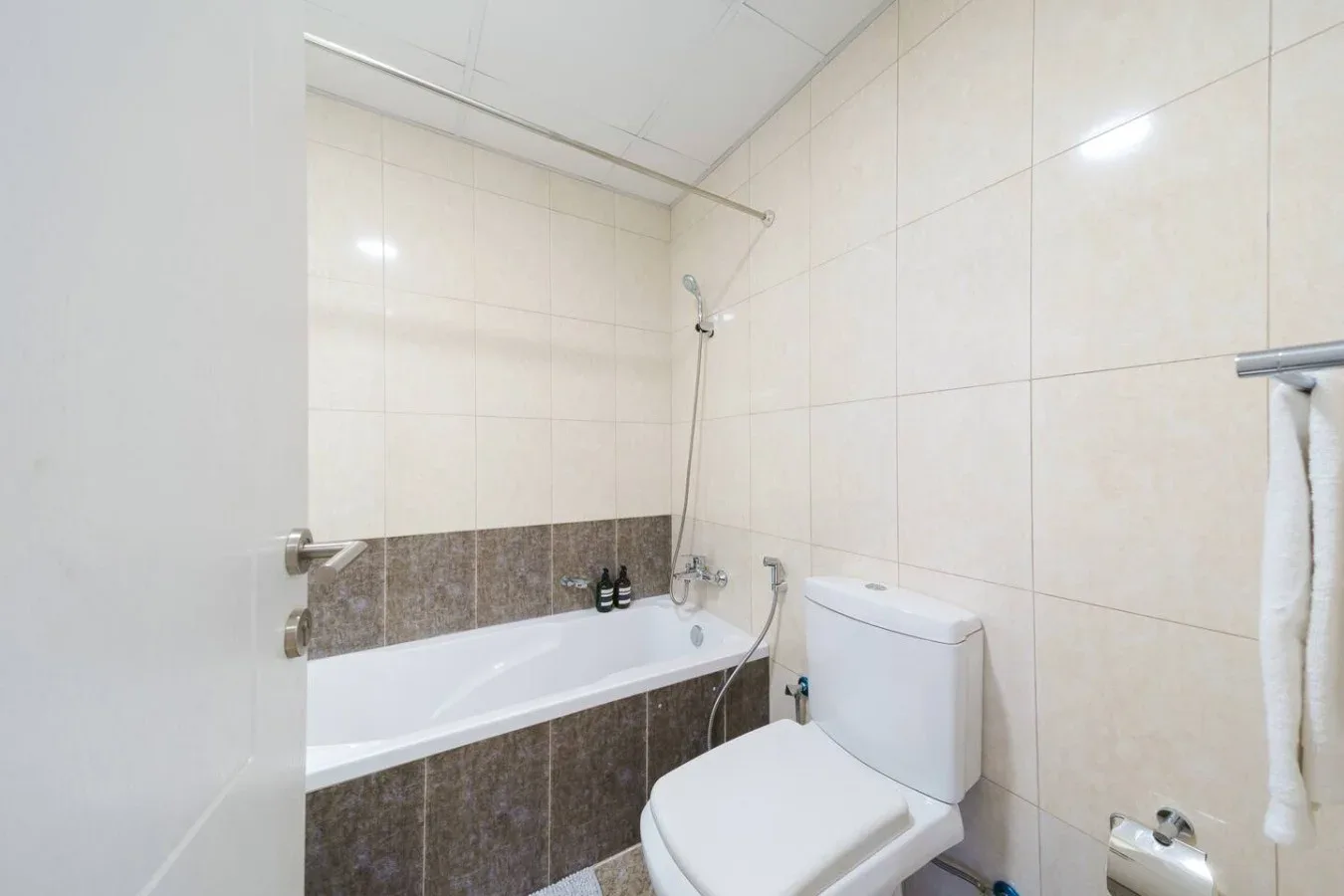 A tiled bathroom with a bathtub, shower, and toilet.