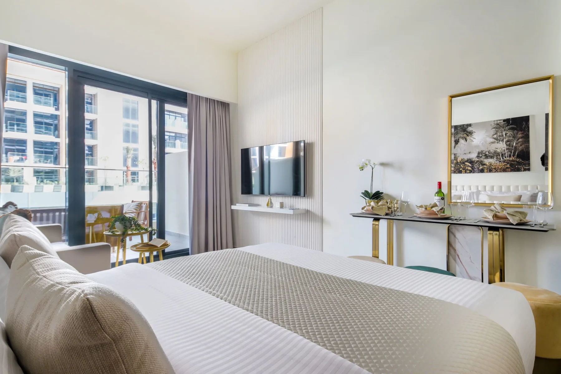 Un dormitorio con una cama grande, un televisor y ventanas de piso a techo.