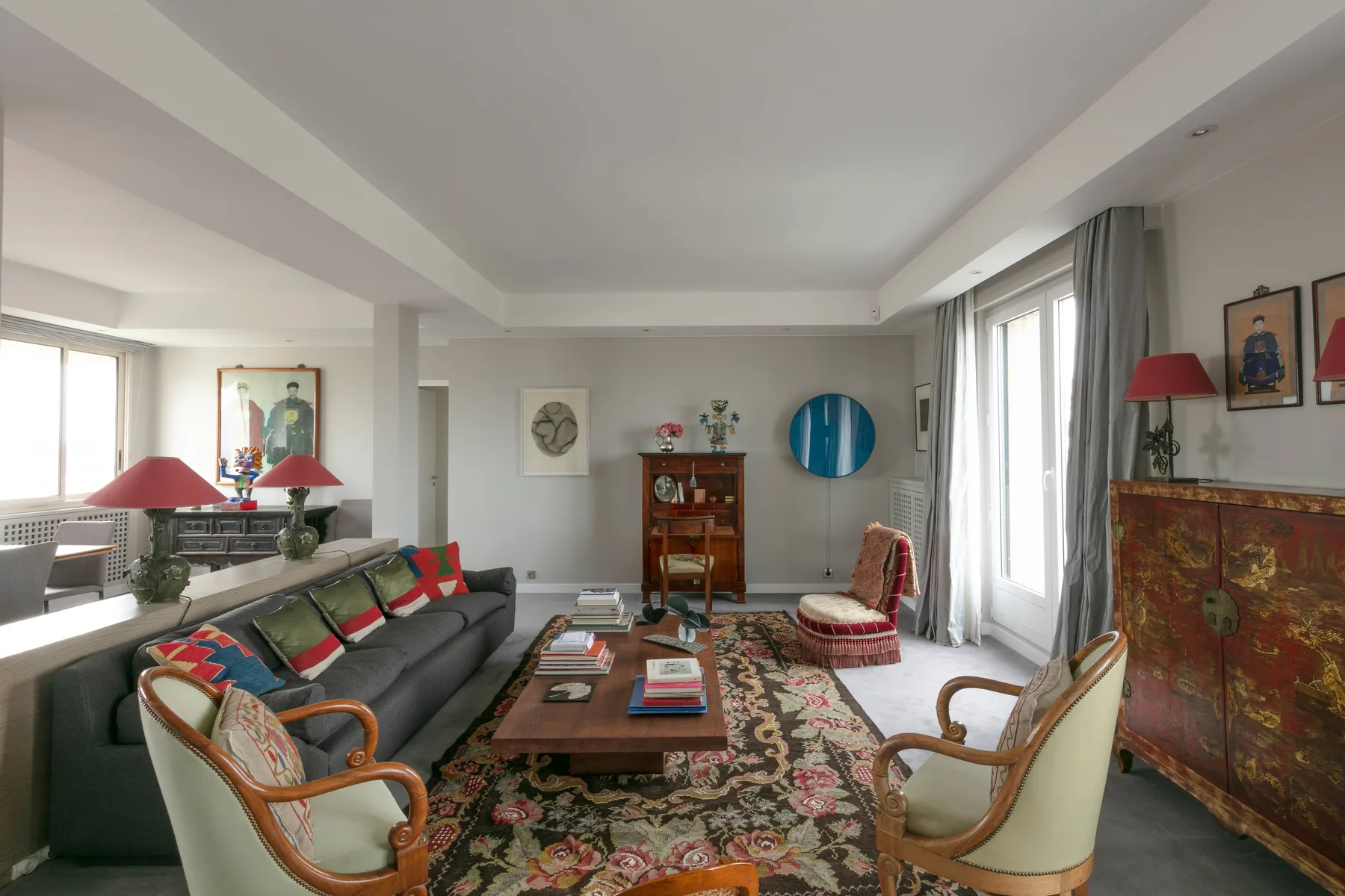 A living room with seating around a coffee table and a patterned rug.