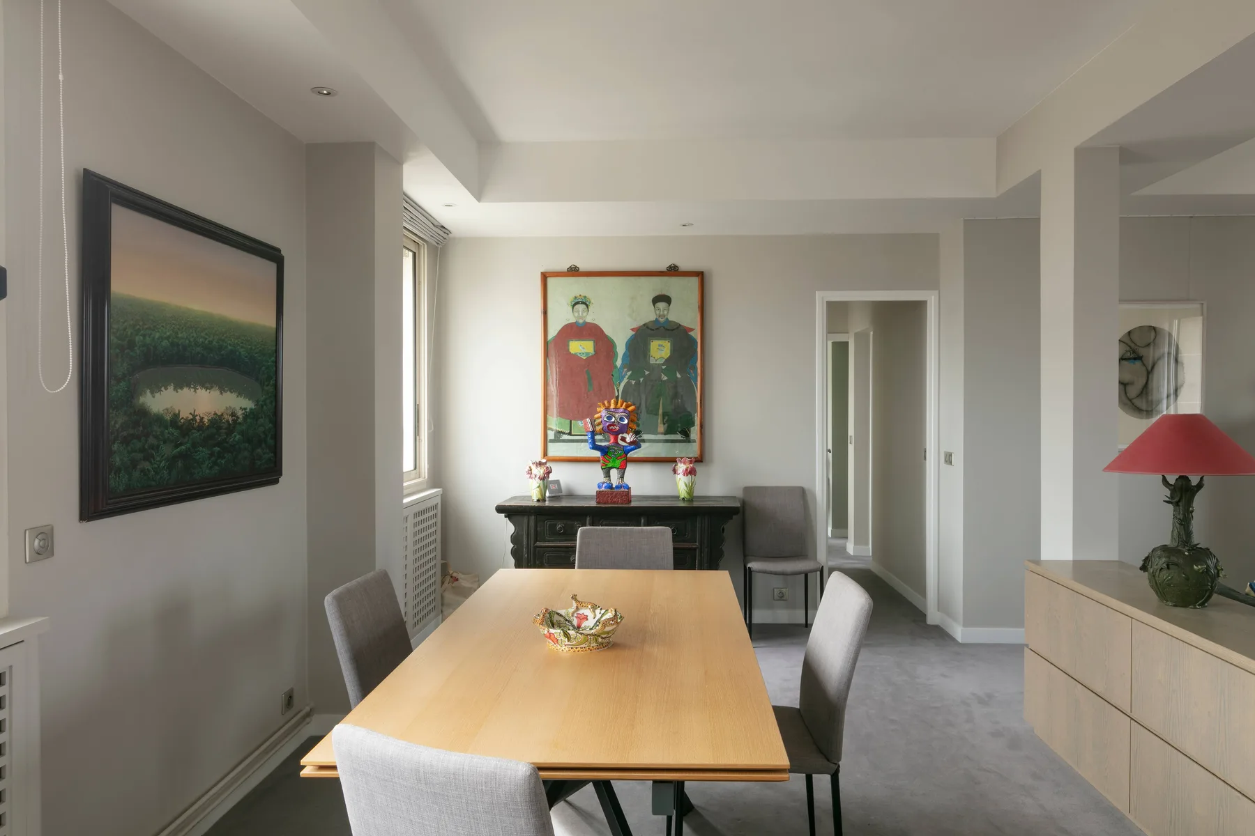 Dining area with a wooden table, chairs, and framed artwork on the walls.