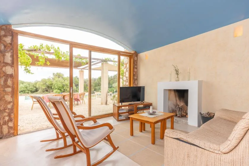 A bright living room opens onto a patio through large glass doors.