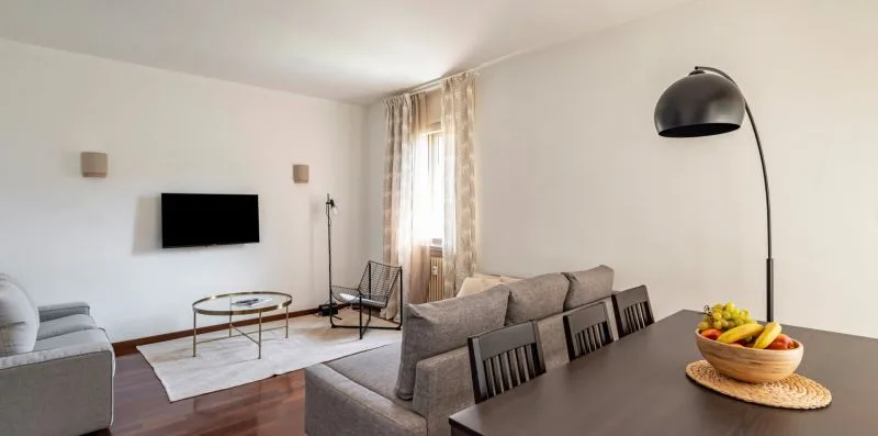 Sala de estar con asientos, televisor y mesa de comedor.