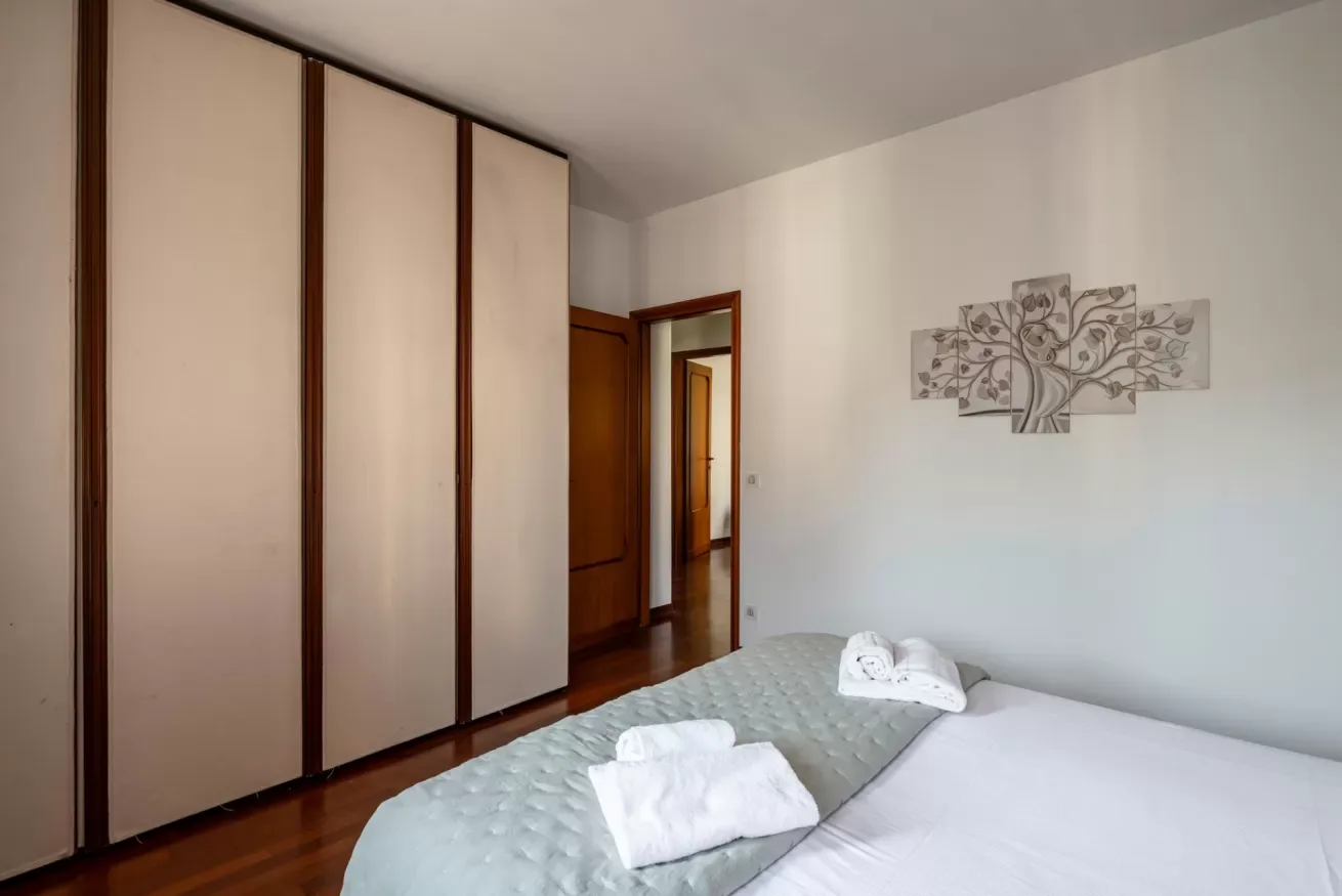 Un dormitorio con una cama y armarios empotrados junto a una pared.