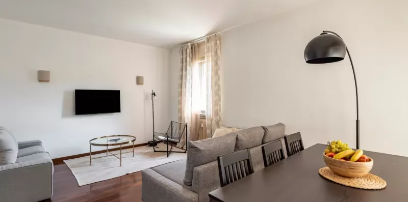Una sala de estar con asientos, un televisor y una mesa de comedor.