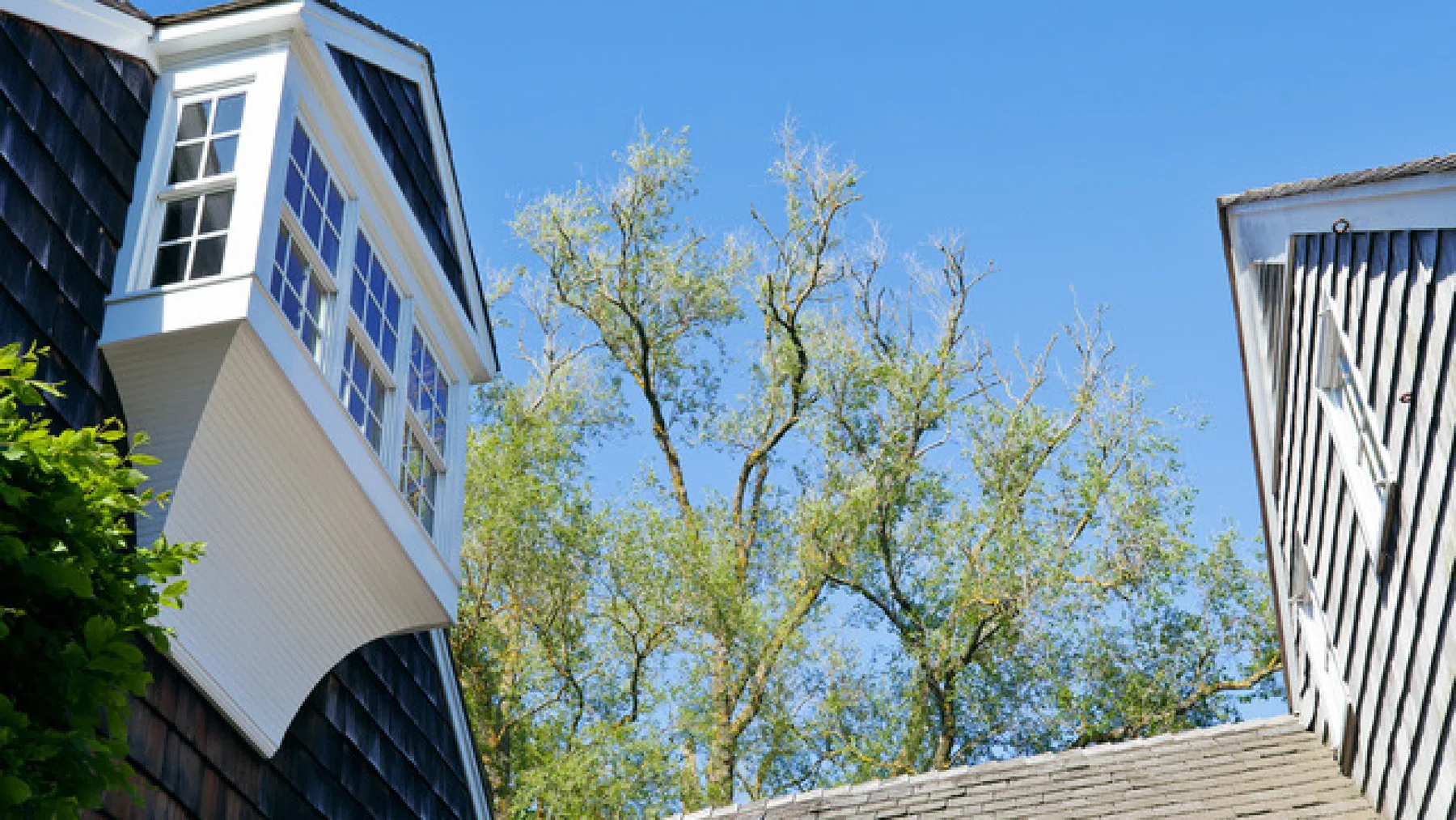 El exterior de una casa con árboles bajo un cielo azul despejado.