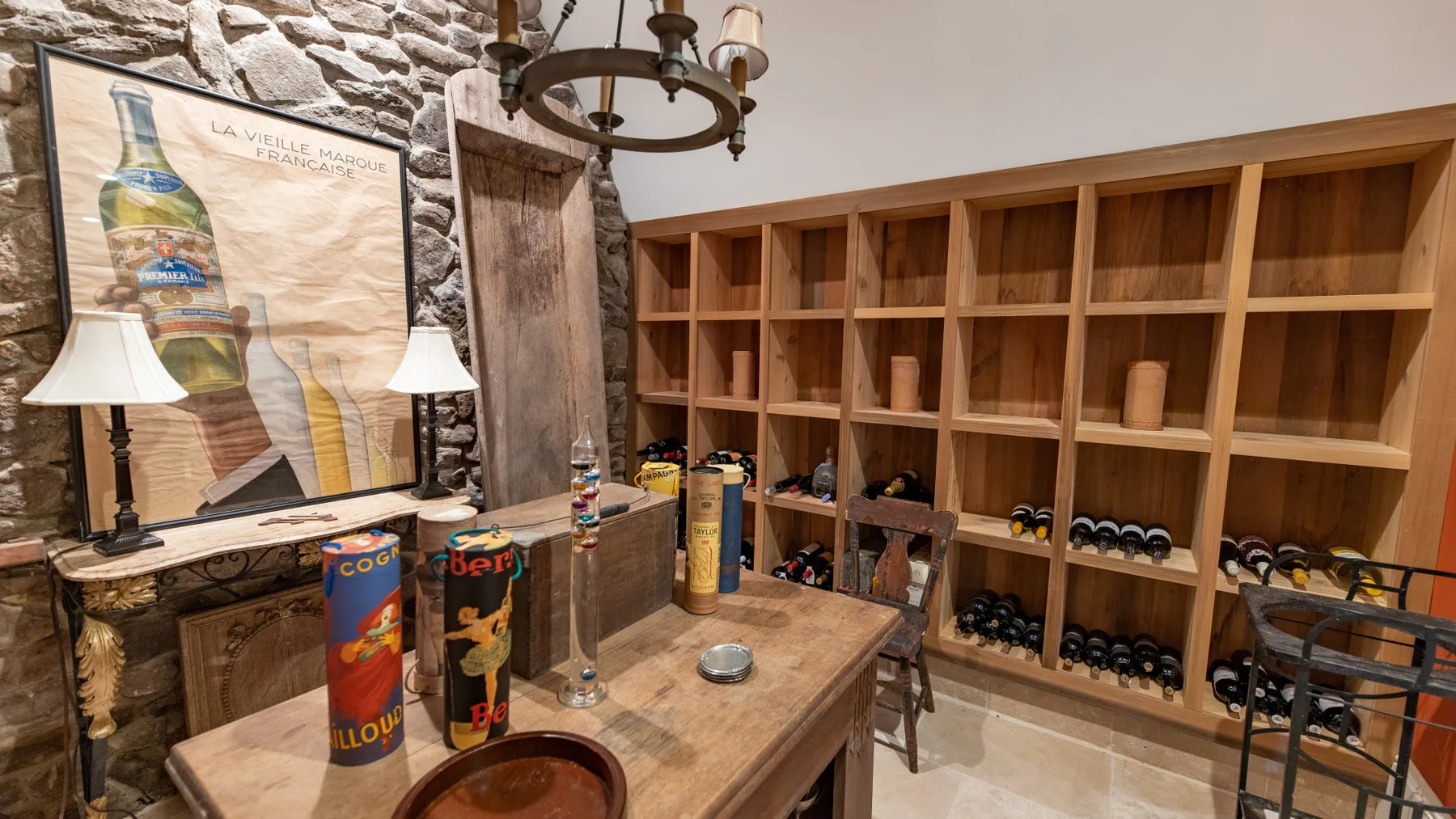 Una sala de almacenamiento de vino con estanterías de madera y una mesa de degustación.
