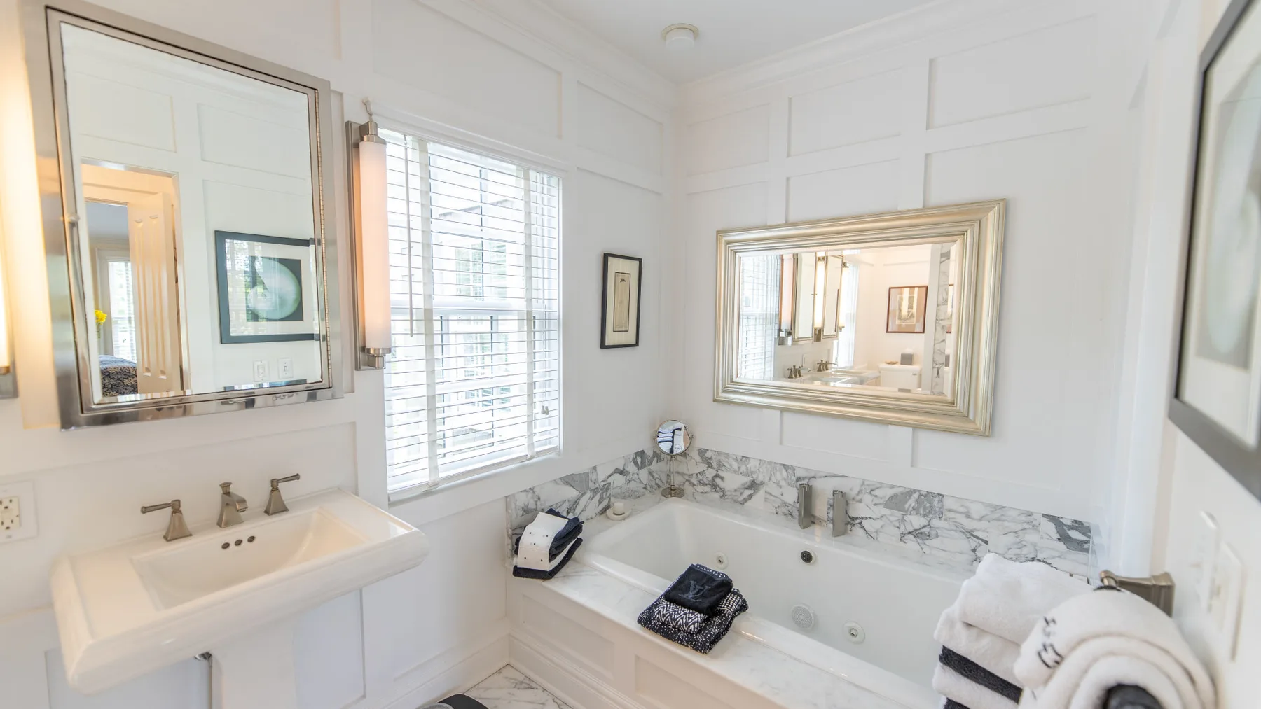 Un baño luminoso con bañera, lavabo y ventana.