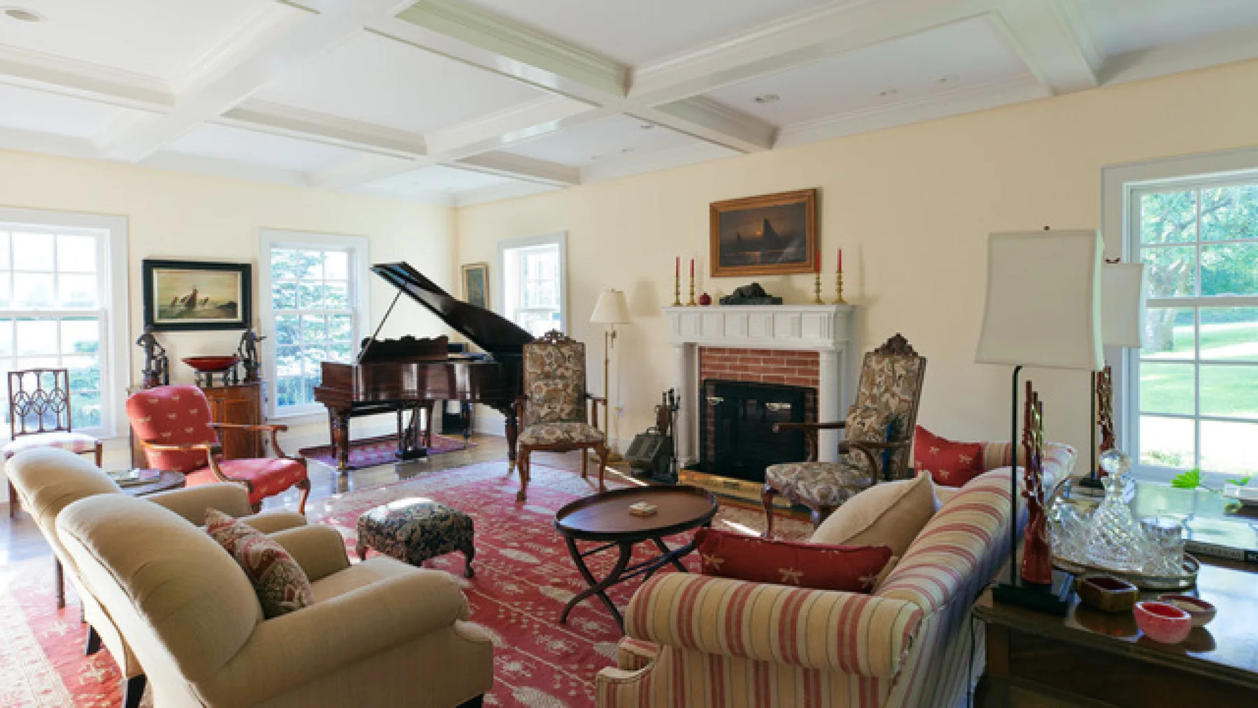 Una luminosa sala de estar con un piano de cola, una chimenea y asientos estampados.