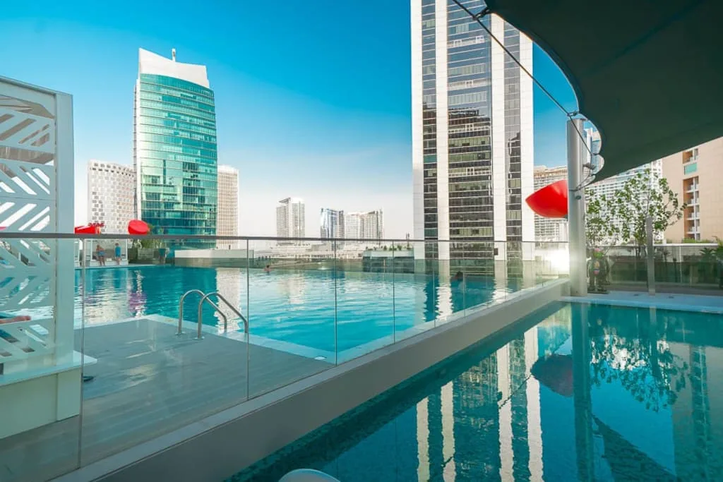 Una piscina en la azotea da a edificios altos cercanos.