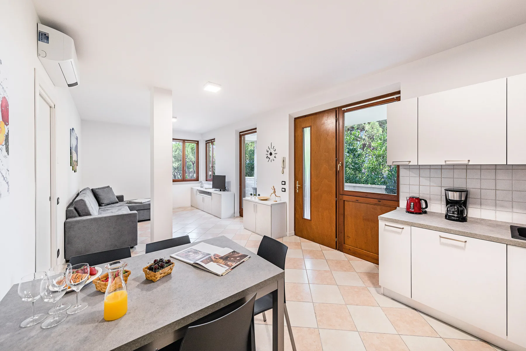 Una sala-comedor de concepto abierto con cocina y una puerta de entrada de madera.