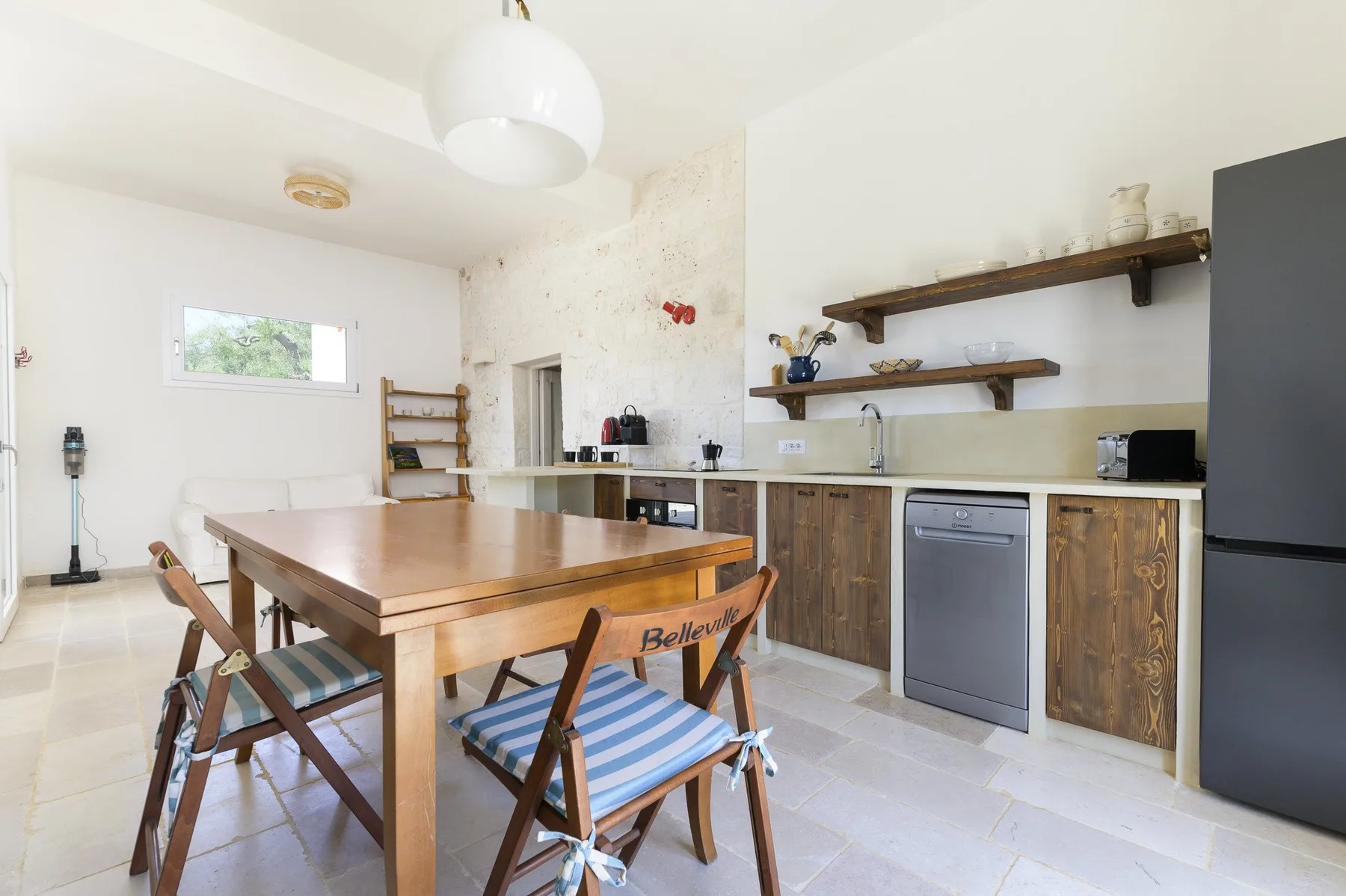 Una cocina y comedor con una mesa de madera y una encimera larga.