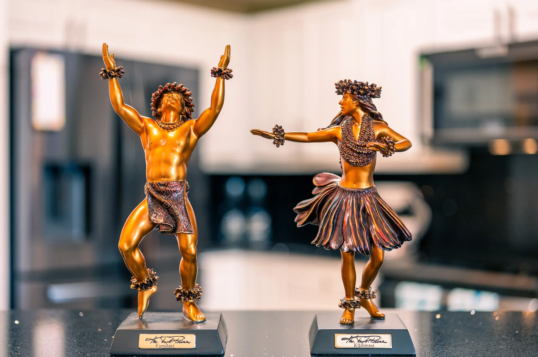 Dos figuras decorativas están sobre una encimera en una cocina.