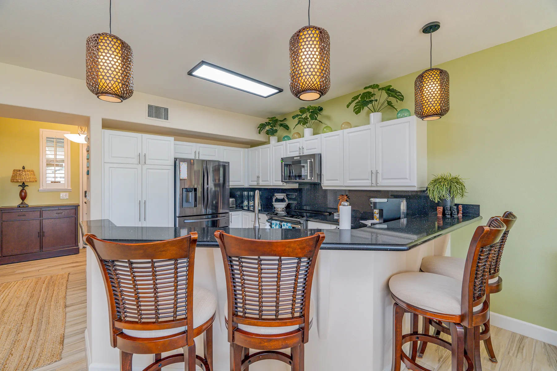 Una cocina luminosa con gabinetes blancos y una isla grande con asientos.