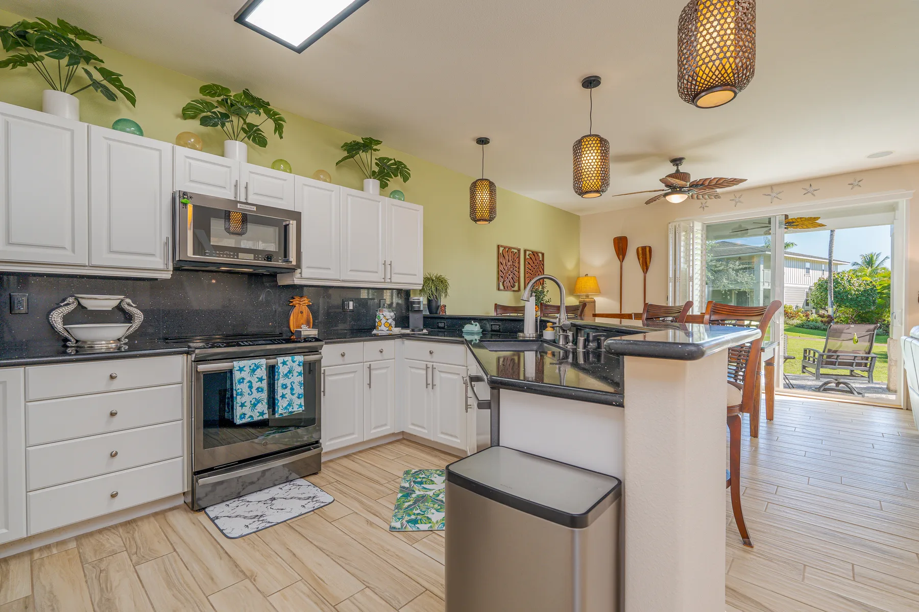 Una cocina luminosa con gabinetes blancos e isla junto a un comedor.