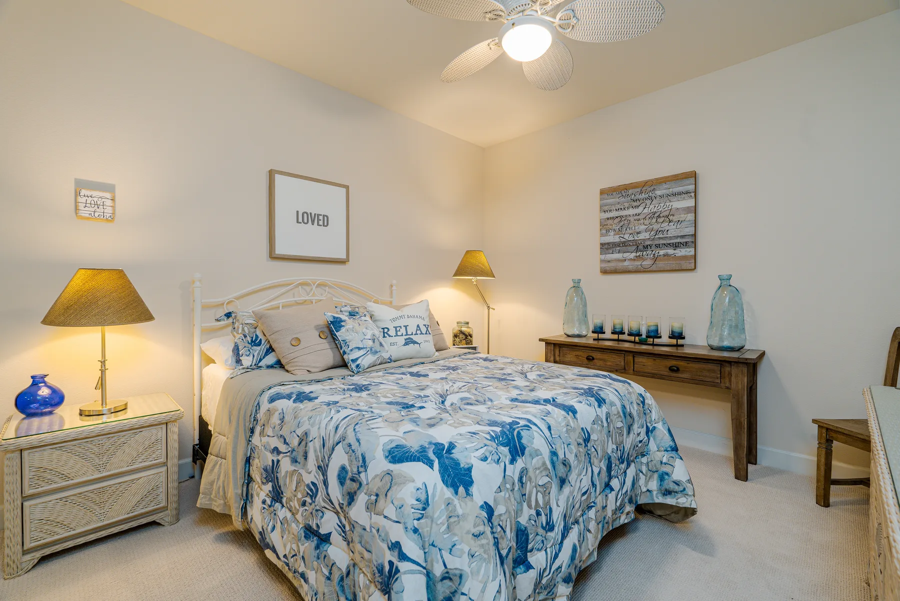 Un dormitorio con una cama vestida con ropa de cama estampada en azul y blanco.