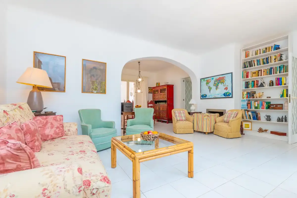 A bright living room has a seating area around a glass-topped coffee table.