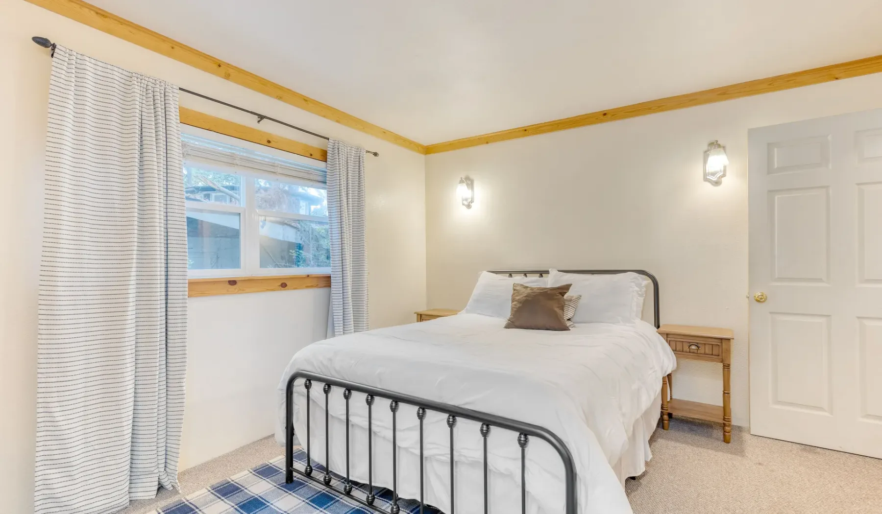 Un dormitorio con una cama junto a una ventana con cortinas.