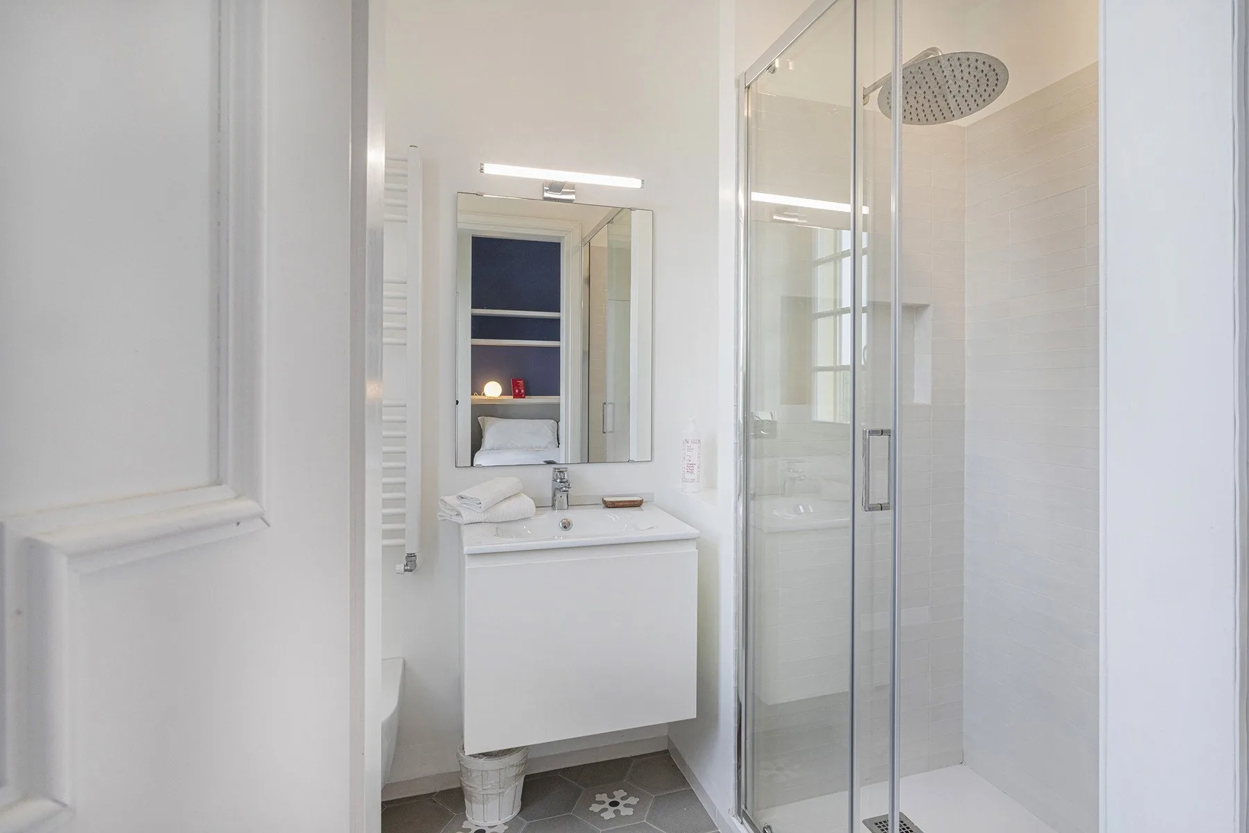 A bright bathroom with a vanity and glass shower.