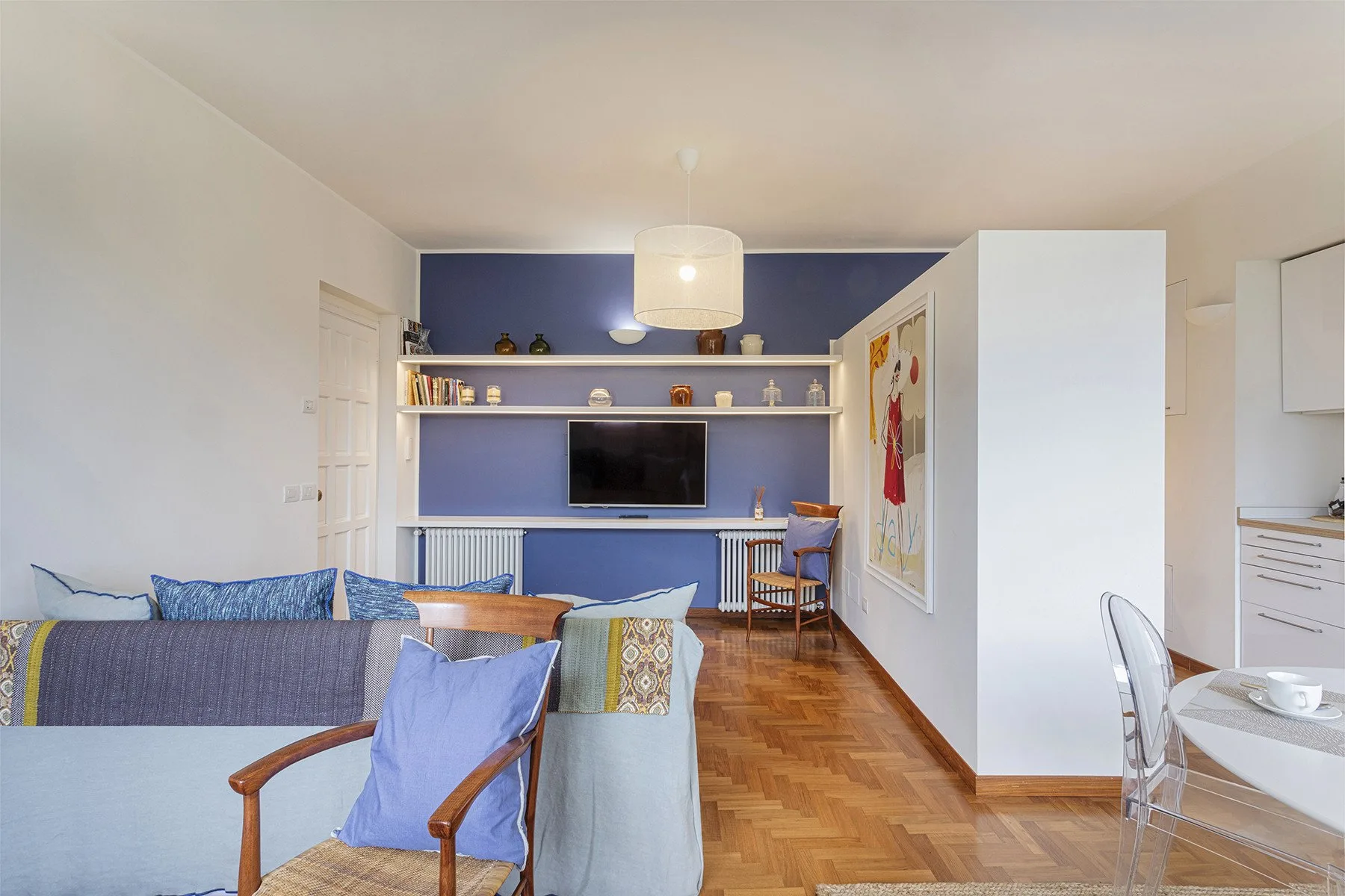 A living room with seating, a television, and built-in shelves.