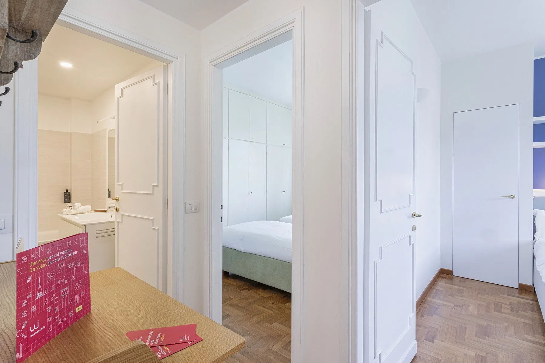 A bright interior hallway opens onto a bathroom and a bedroom.