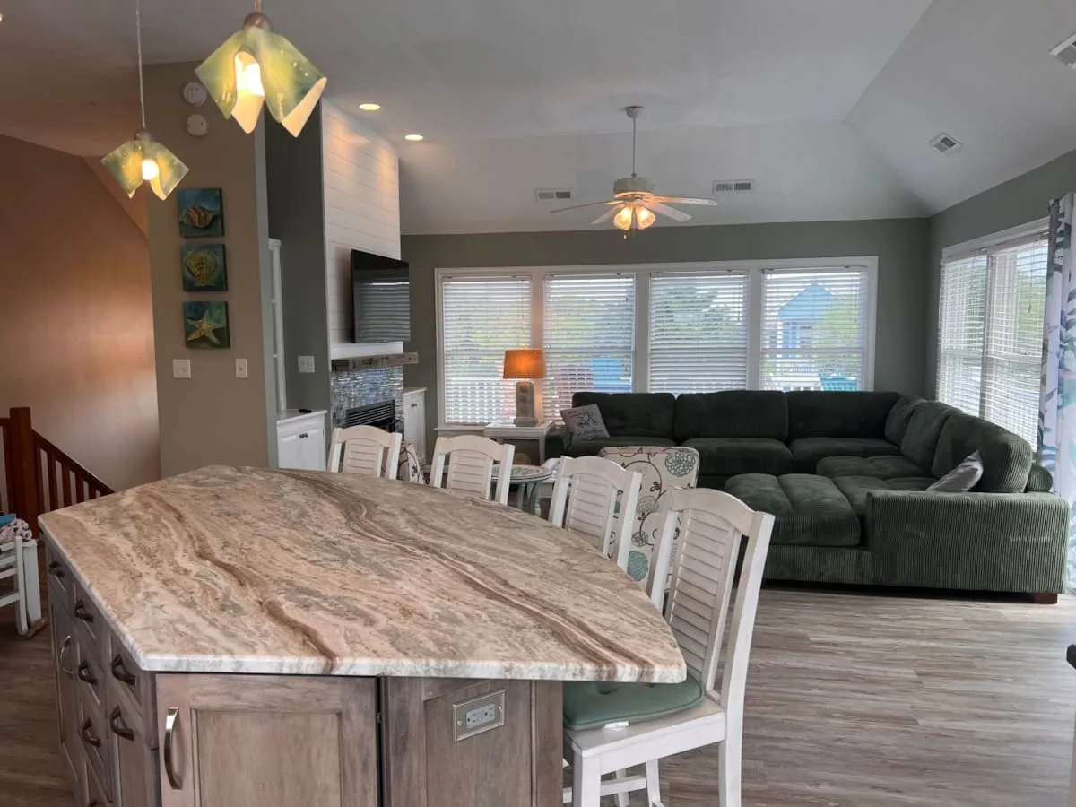 An open-plan living and dining area with a large table and seating by the windows.
