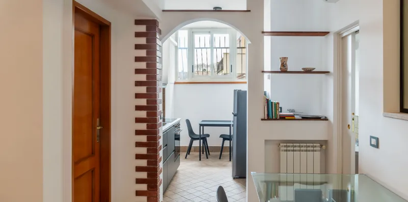 A bright interior hallway opens into a dining area with built-in shelves.