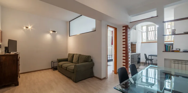 Una luminosa sala de estar y comedor con asientos y una mesa de vidrio.