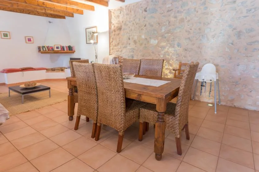 A dining area with a wooden table and woven seating.