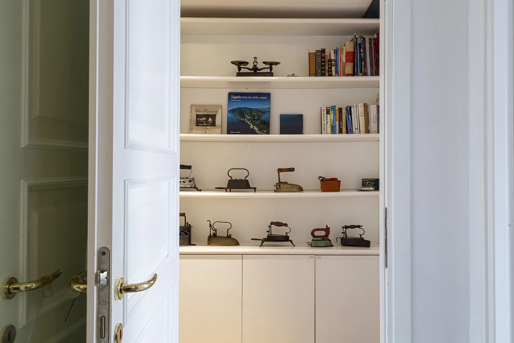 Un armario empotrado exhibe libros y pequeños objetos decorativos.