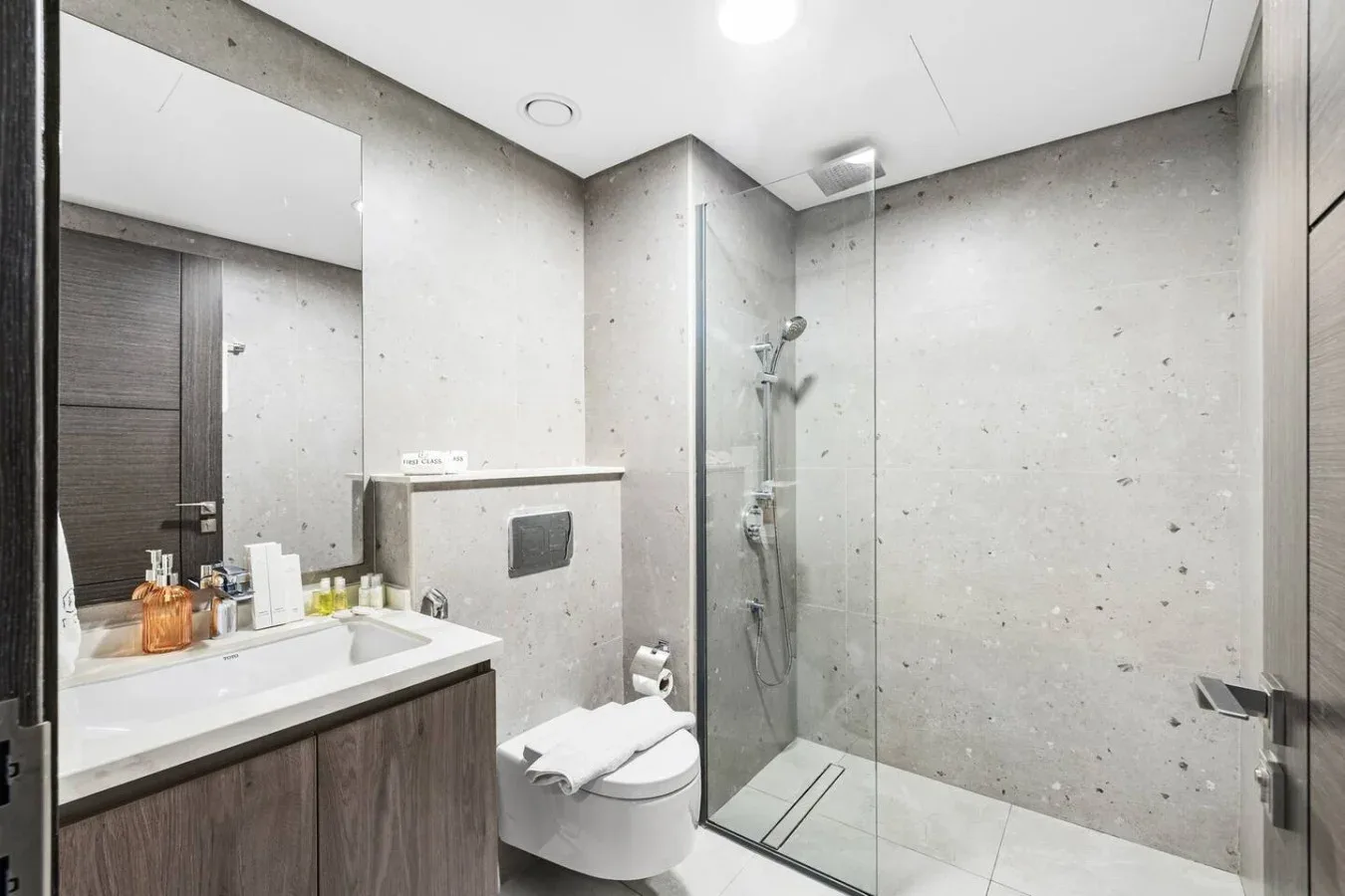 A modern bathroom with a sink, toilet, and glass shower.