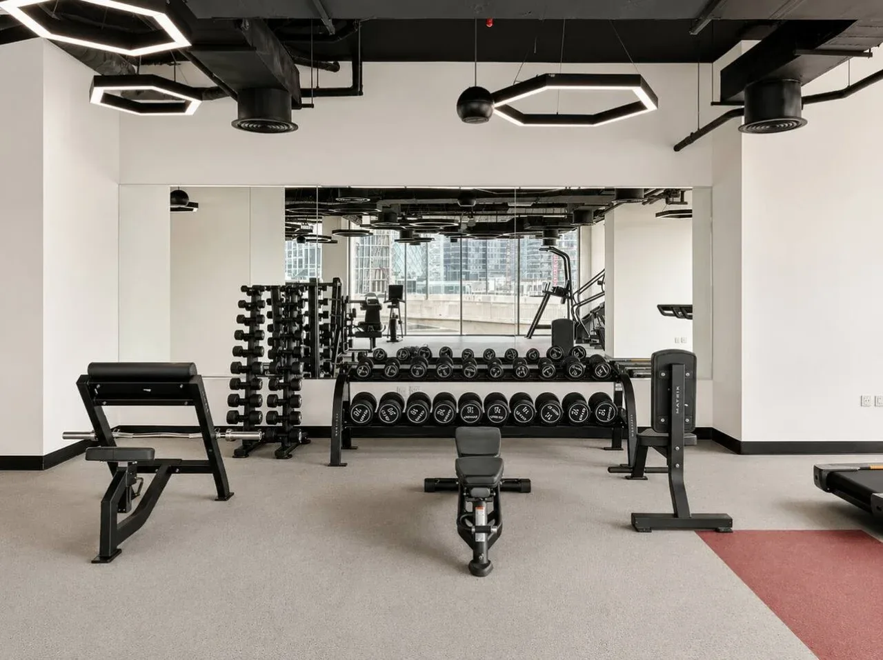 A gym with weight racks, dumbbells, and workout benches.