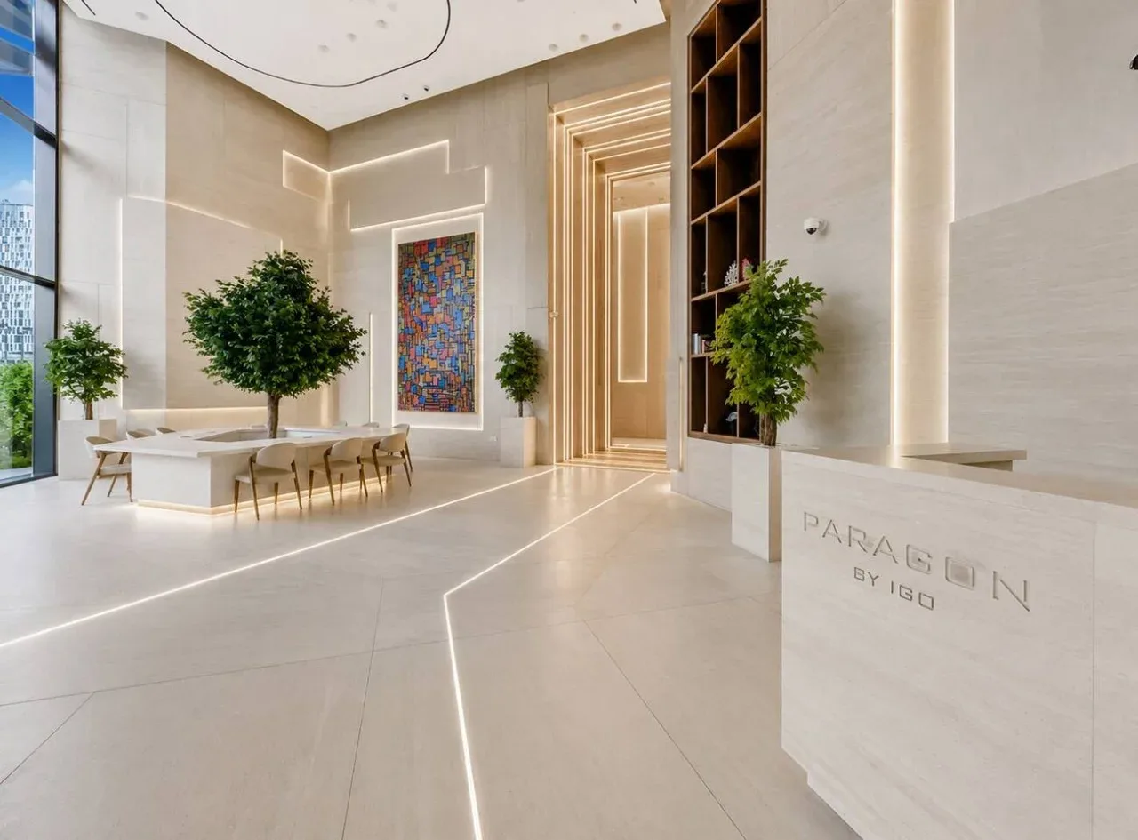 A bright lobby with a reception desk, seating, and a colorful wall artwork.