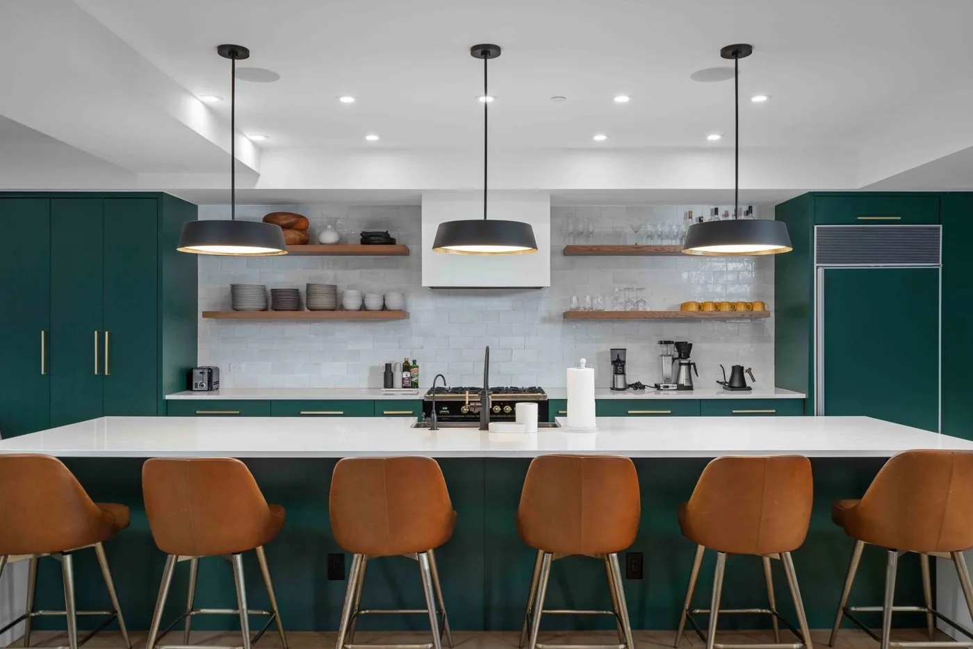 Una cocina moderna con una barra larga, asientos y estantes abiertos.