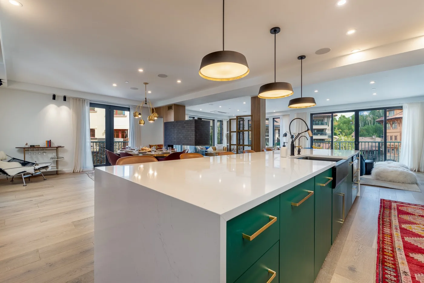 Una cocina moderna con una isla grande y gabinetes verdes.