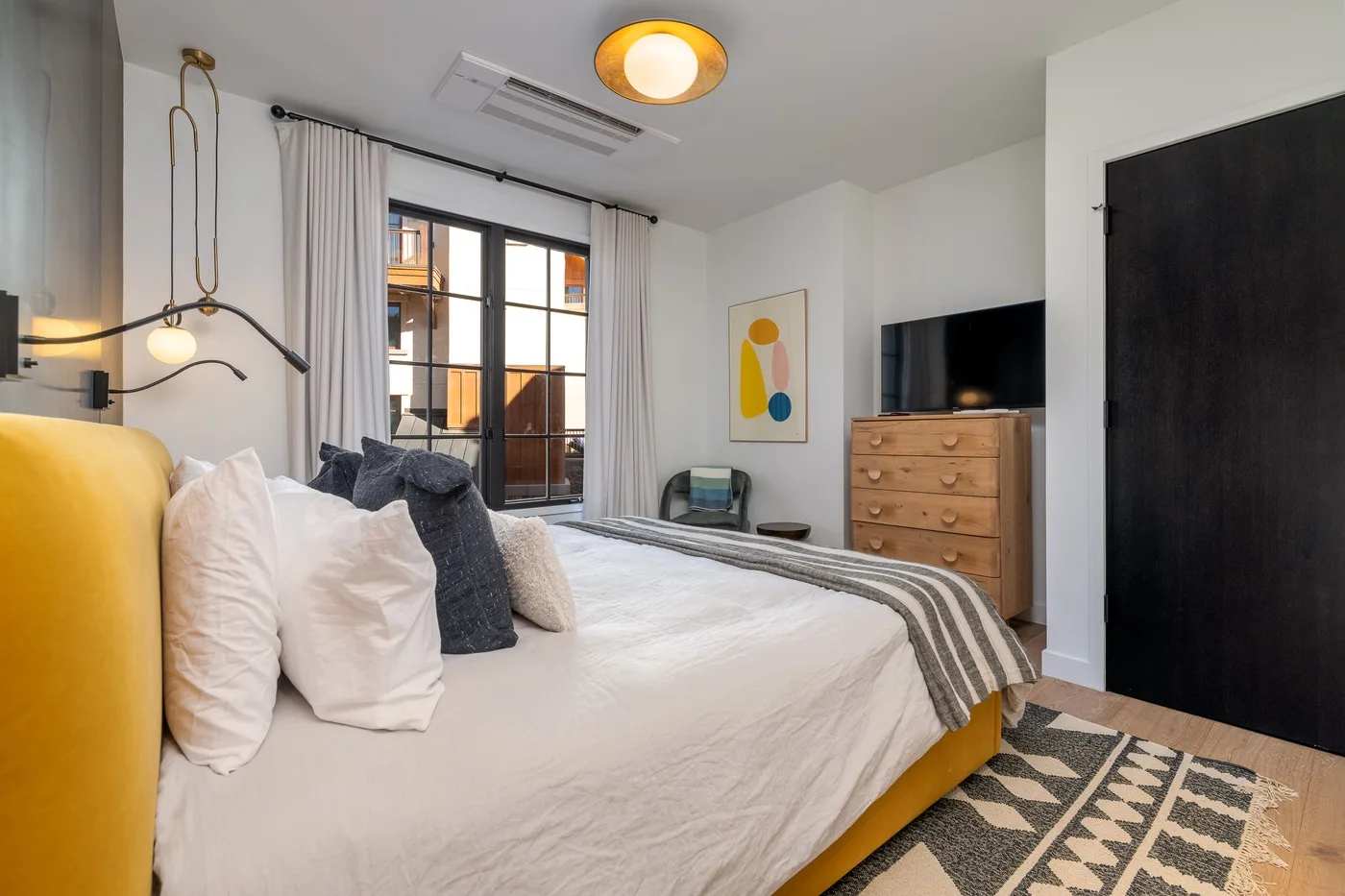 Un dormitorio con una cama, una ventana y una cómoda.