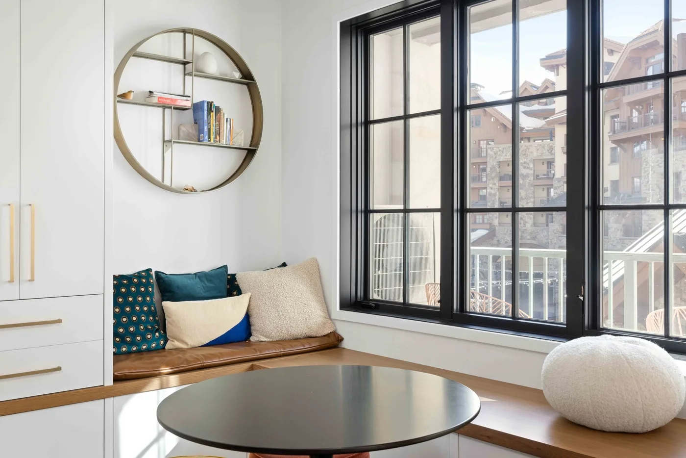 Una luminosa sala de estar con asientos junto a la ventana y una mesa de centro redonda.